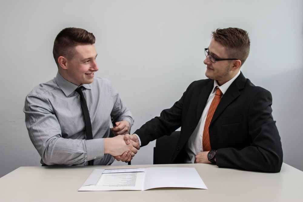 Two men shaking hands over a bonded contract