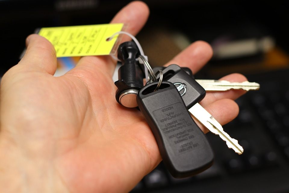 A person holding car keys after buying a car.